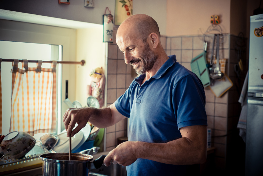 miggle age man cooking  at home