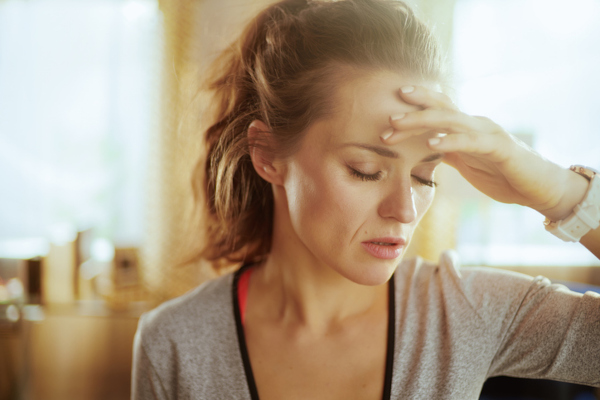 Portrait of stressed healthy sports woman in sport clothes at modern home.